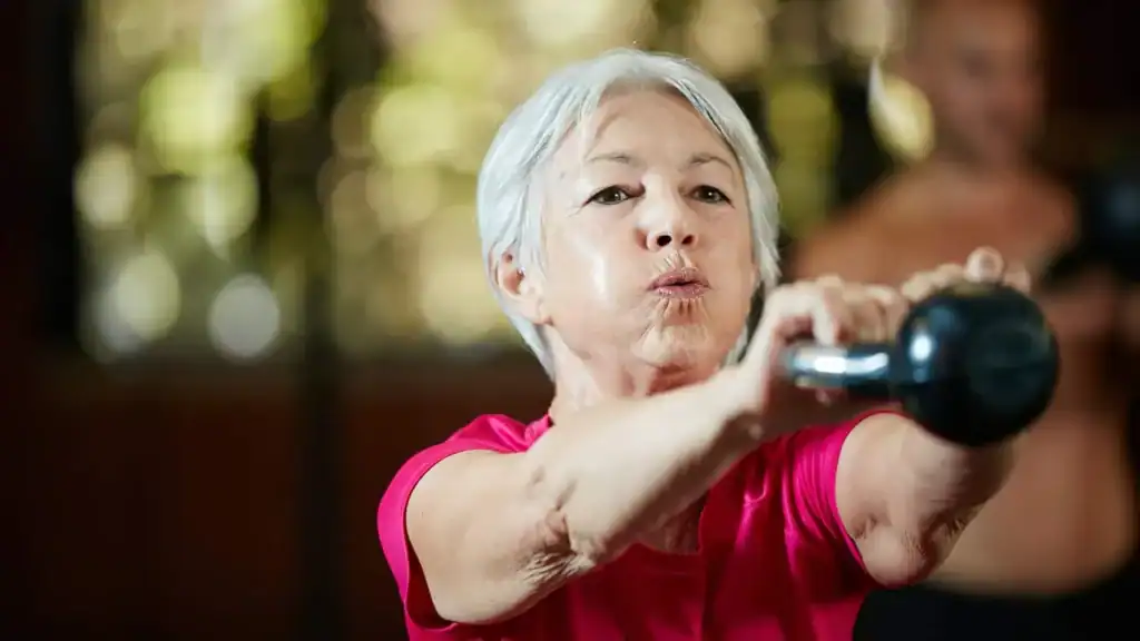 Toning Arms After 60: Empowering Womens Fitness Through Effective Weight Training 1 Older woman doing weight training Newbury to help her strength and longevity