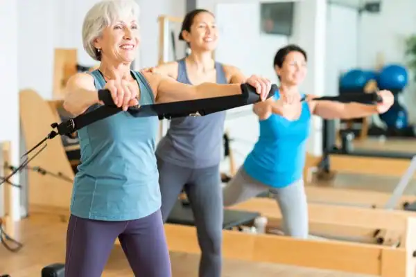 Toning Arms After 60: Empowering Womens Fitness Through Effective Weight Training 2 older woman doing weight training Newbury and resistance in the gym to tone upper arms