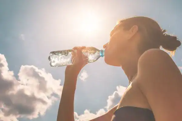 Hydration: The Secret Ingredient for a Toned Stomach and Enhanced Fitness 3 Image of woman drinking water to hydrate Newbury after run.
